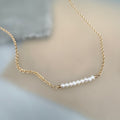 Gold chain necklace with pearls on a soft background